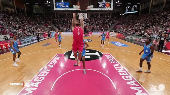 Ein Basketballer setzt zu einem Dunk an.