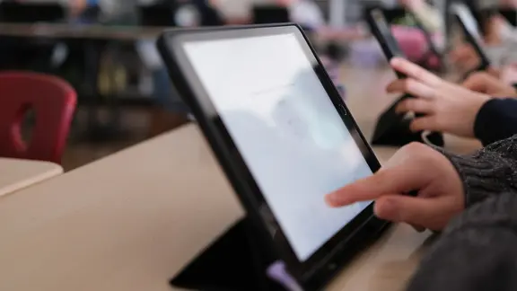 Haende eines Jungen an einem Tablet