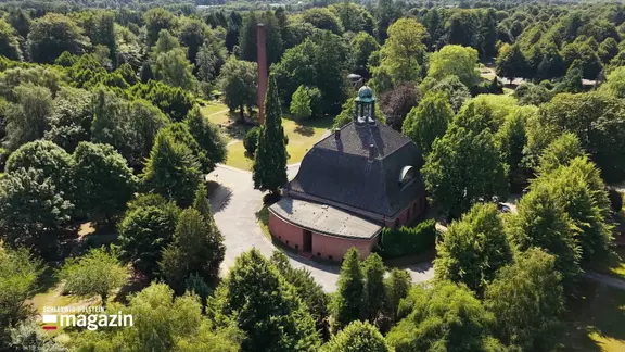 Ein Gebäude in einer Grünanlage aus der Vogelperspektive.