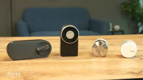 Smart-Lock-Türschlösser verschiedener Hersteller liegen auf einem Tisch.
