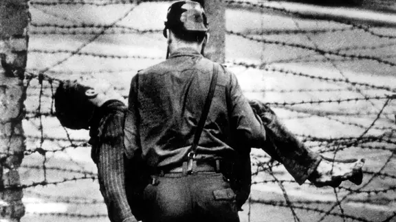 Ein Grenzsoldat trägt den bei seinem Fluchtversuch an der Berliner Mauer erschossenen Peter Fechter am 17. August 1962 davon.
