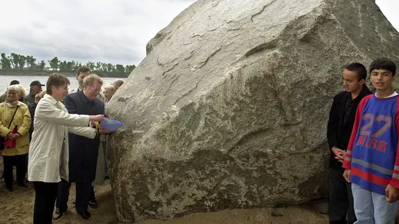 Auf den Namen "Alter Schwede" taufen am 6. Juni 2000 Hamburgs Zweite Bürgermeisterin Krista Sager (l.) und der schwedische Generalkonsul Leif H. Sjöström einen Riesenfindling mit Elbwasser. Der etwa 217 Tonnen schwere Findling aus der Eiszeit war 1999 aus der Elbe geborgen worden.