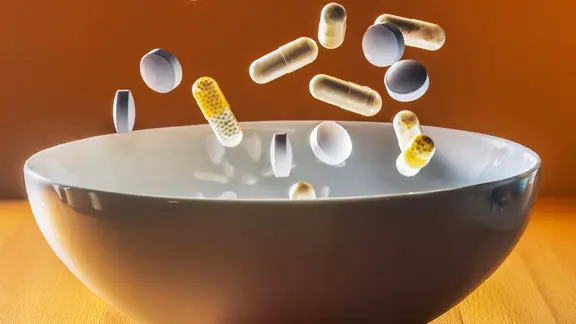 Vitamin K: Tabletten fallen in eine Schüssel