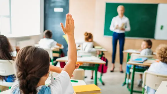 Eine Lehrerin steht vor einer Klasse.