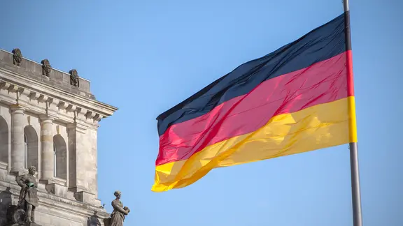 Eine Deutschlandflagge weht vor dem Bundestag