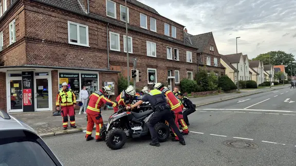 Einsatzkräfte schieben eines der beiden verunfallten Quads von der Straße.