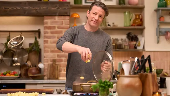 Der englische Starkoch Jamie Oliver steht am Herd