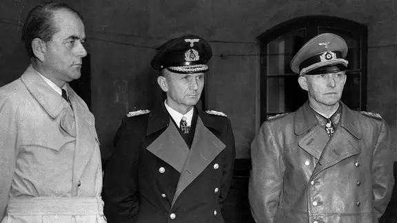 Mitglieder der deutschen Regierung "Dönitz": Minister für Rüstung und Kriegsproduktion Albert Speer (links), Großadmiral Karl Dönitz (Mitte) und General Alfred Jodl warten in einem Hof ​​in Flensburg nach ihrer Festnahme durch britische Truppen am 24. Mai 1945.