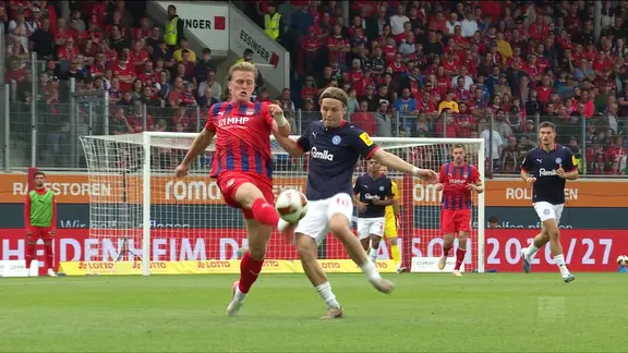 Zweikampf-Szene aus einem Fußballspiel zwischen Heidenheim und Holstein Kiel.