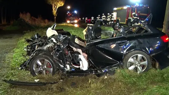 Ein Autowrack steht nach einem Unfall neben einer Straße.