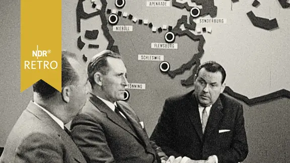 Minderheitenführer Harro Marquardsen und Berthold Bahnsen vor Karte des dänisch-deutschen Grenzgebiets im Fernsehstudio beim Interview