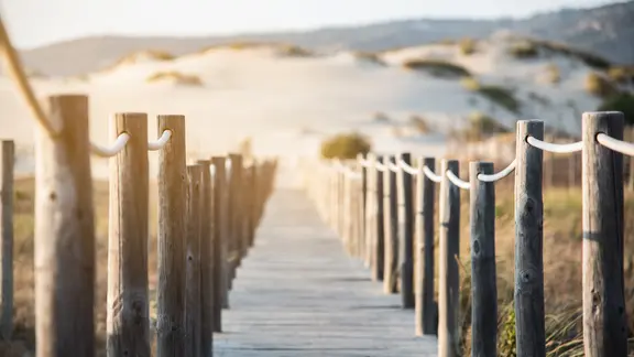 Ein Steg, der an einen Strand führt.