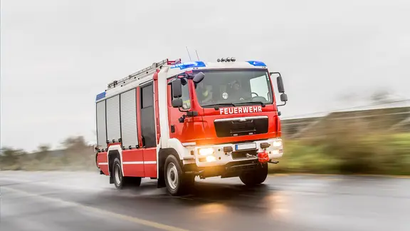 Ein Feuerwehrfahrzeug fahrend auf einer Straße