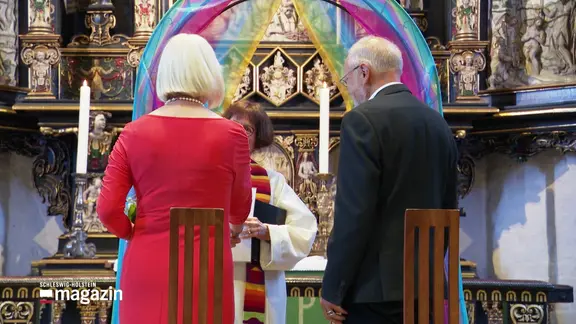 Bei der Trauung eines älteren Paares vor dem Altar in einer Kirche.