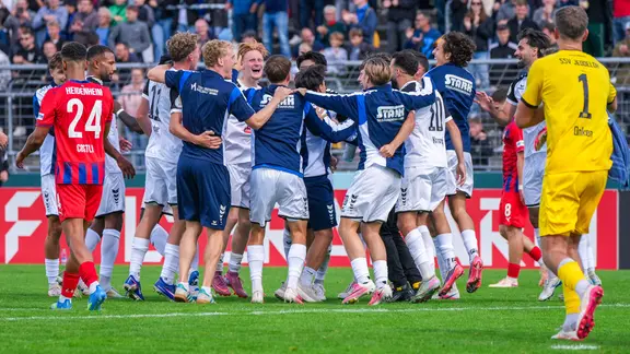 Die Regionalliga-Fußballer des SSV Jeddeloh II bejubeln ihren Sieg im DFB-Pokal gegen den 1. FC Heidenheim 