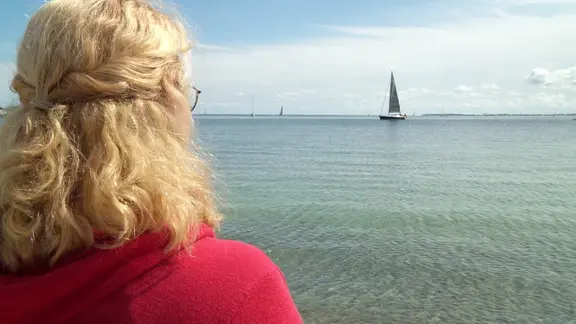Eine Frau blickt aufs Wasser.