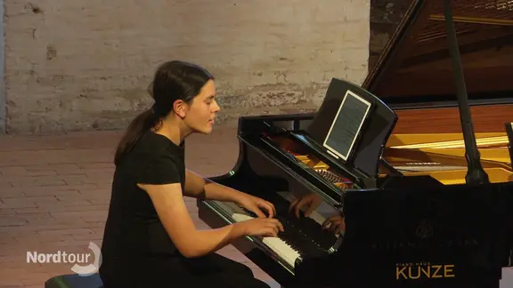 Eine Pianistin gibt ein Konzert in der Kirche.