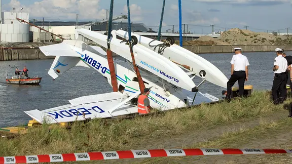 Das Wrack eines abgestürzten Wasserflugzeugs wird von Bergungsmannschaften der Feuerwehr im Hafen in Hamburg geborgen.