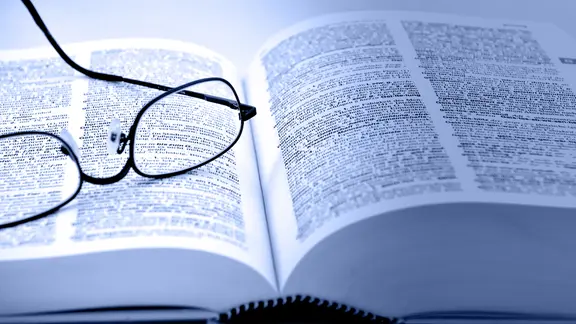 Aufgeschlagenes Buch und Brille