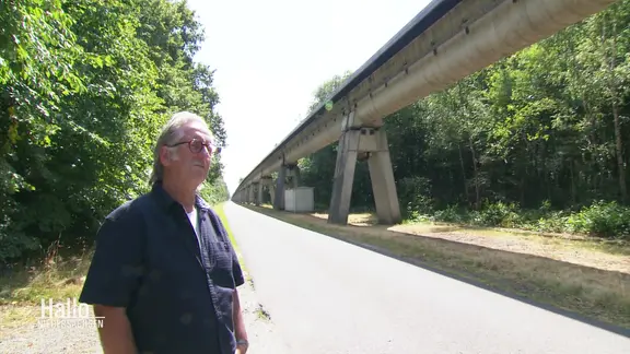 Dirk Dinnus steht vor der ehemaligen Transrapid-Strecke in Lathen. 