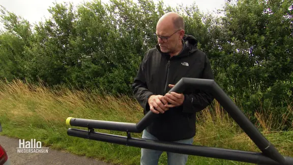 Martin Kleingünther hält eine schwarze Drainage in den Händen.