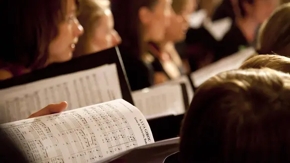 Chorsänger halten Noten in den Händen