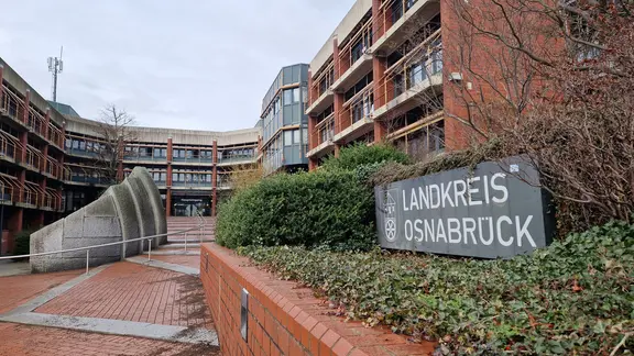 Ein Schild mit der Aufschrift "Landkreis Osnabrück" steht vor dem Kreishaus.