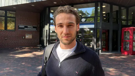 Ein Student schaut in die Kamera.