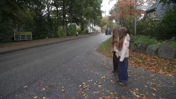 Charlotta und Mathilda stehen an der Straße.