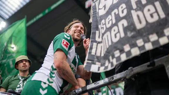 Patrick Weiser feiert nach dem Sieg gegen den FC Augsburg mit den Fans von Werder Bremen