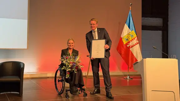 Daniel Günther überreicht Kirsten Bruhn die Urkunde zur Ehrenbürgerin in SH.