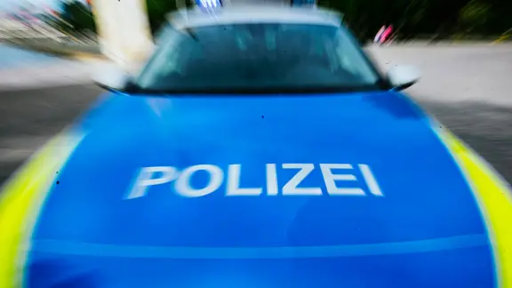 Ein Einsatzfahrzeug der Polizei frontal in Unschärfe.