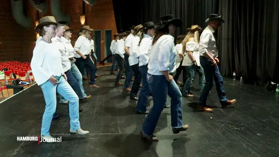 Die Line-Dance-Gruppe aus Wilhelmsburg in Jeans, mit weißen Hemden und Hüten