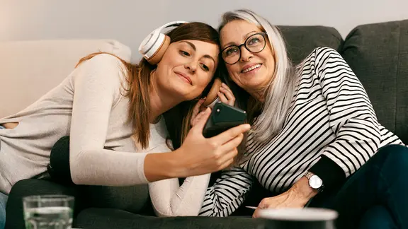 Zwei Frauen hören über Kopfhörer Musik.