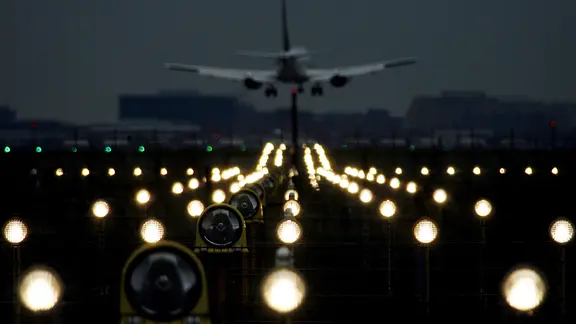 Ein Flugzeug landet im Dunkeln am Flughafen.