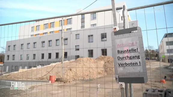 Ein abgesperrtes Gelände mit einem großen Gebäude.