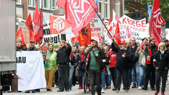 Teilnehmer einer Demonstration mit Fahnen und Transparenten.