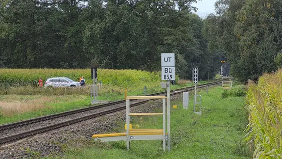 An einer Bahnstrecke stehen Polizeibeamte.
