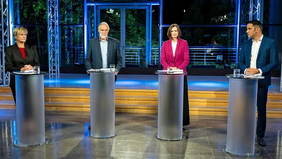 Die Politiker Simone Oldenburg ( Linke), Peter Schabbel (BSW), Claudia Müller (Grüne) und Daniel Peters (CDU) stehen in einem TV-Studio nebeneinander.