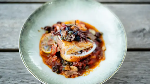 Ein Teller mit gefülltem Tintenfisch in Tomatensugo.