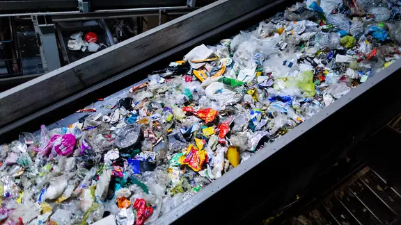 Verschiedene Verpackungsabfälle (PET, PE, PP, PS) werden in einer Sortieranlage getrennt.