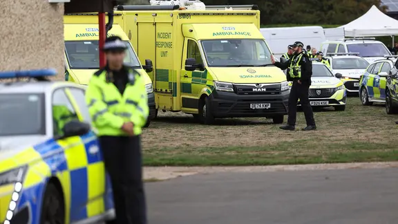 Britische Polizisten befinden sich in der Nähe ihrer Fahrzeuge und Rettungswagen.