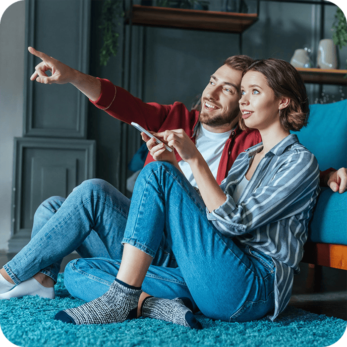 Couple pointing at Google Home features in their home