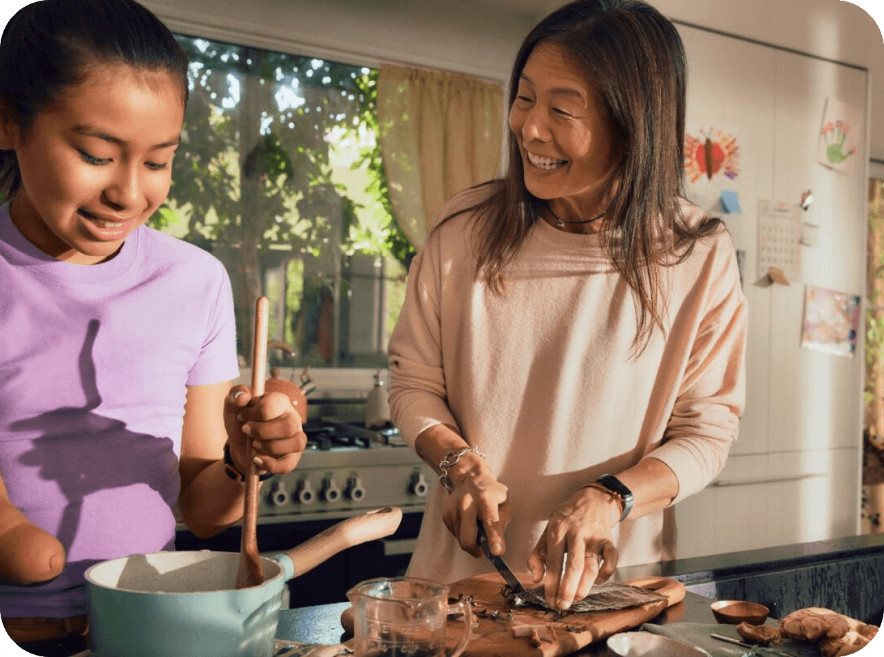 mother cooking at home with her daughter talking and laughing together