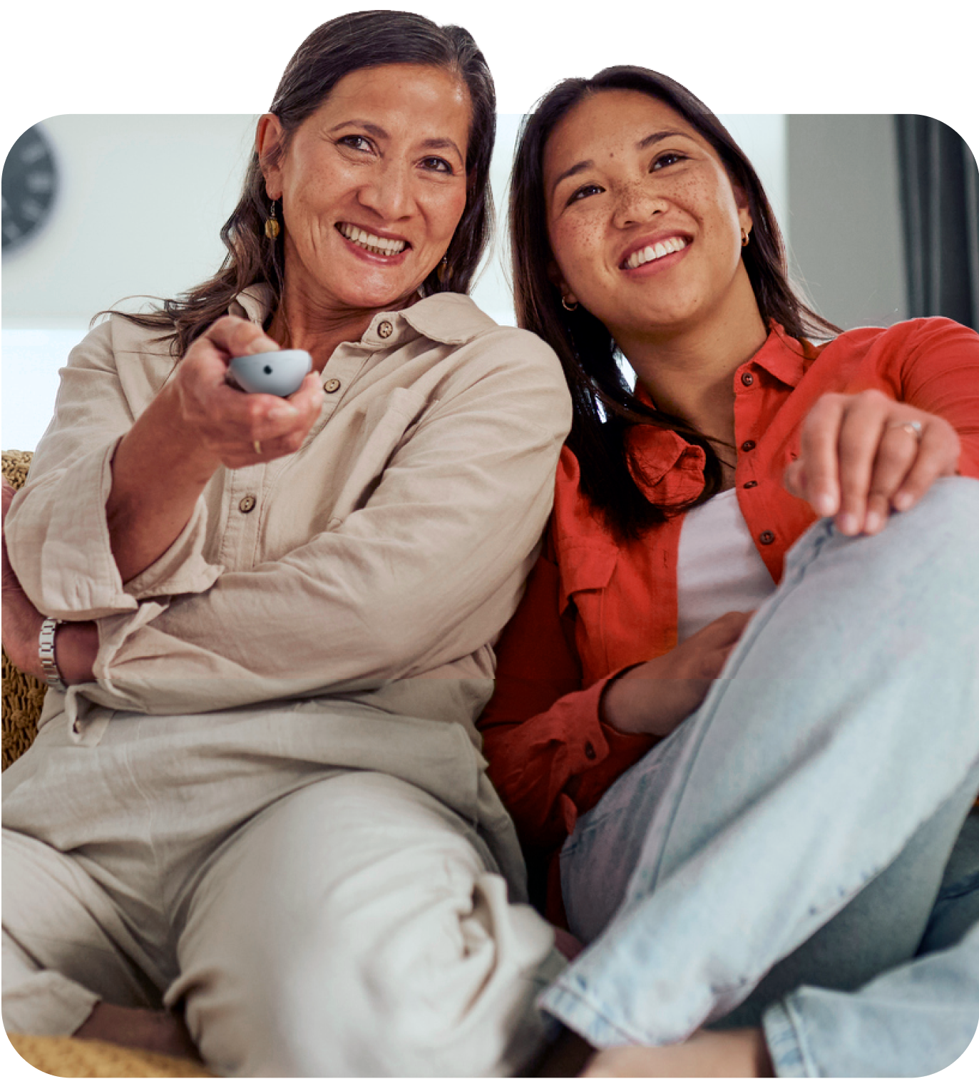 Mother and daughter watching Google TV and holding a remote.