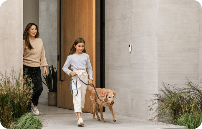 mother and daughter taking golden retriever for a walk