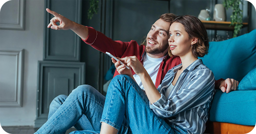 Couple pointing at Google Home features in their home
