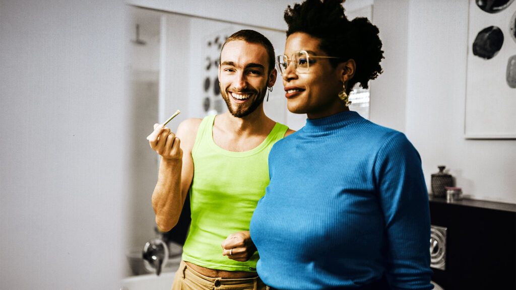 two people standing next to each other with brightly colored shirts