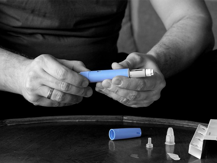 Person in a seated position checking to see if their Ozempic pen is empty. see if their Ozempic pen is