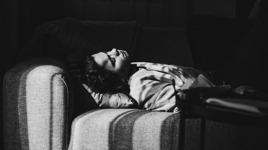 A person who may be experiencing nausea and vomiting lying down in bed.-1